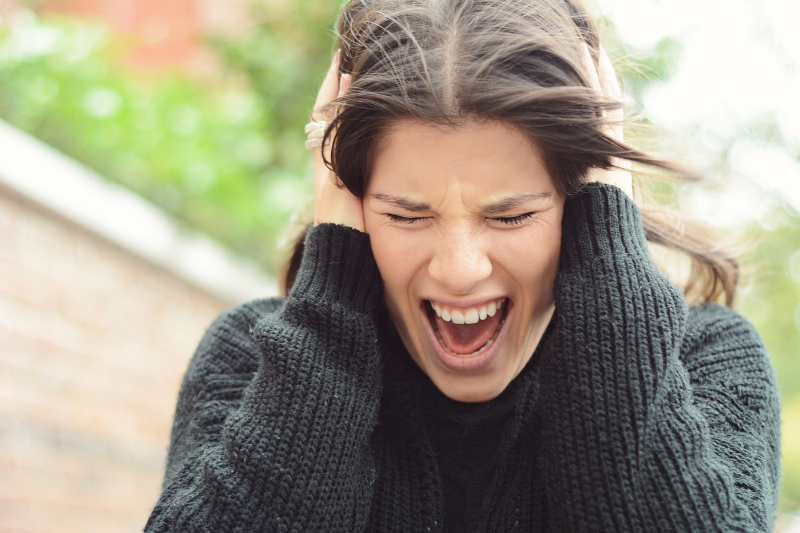 Mujer gritando agarrándose la cabeza